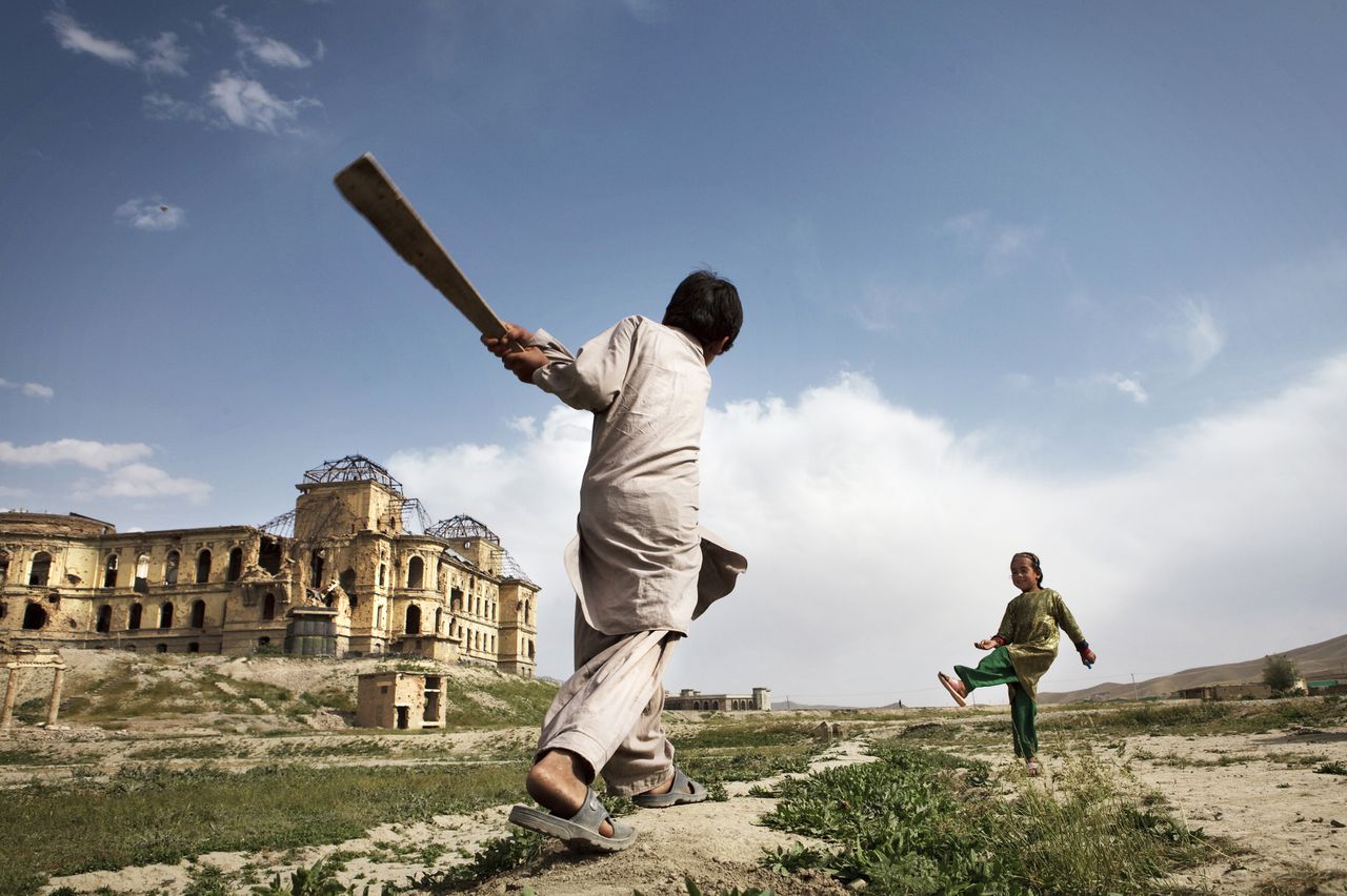 Children play cricket in front of Darul Aman Palace in Kabul, Afghanistan on May 15, 2012. The palace, which was built by King Amanullah Khan in the early 1920s, was ruined after it has been through several war. Photo by Kuni Takahashi