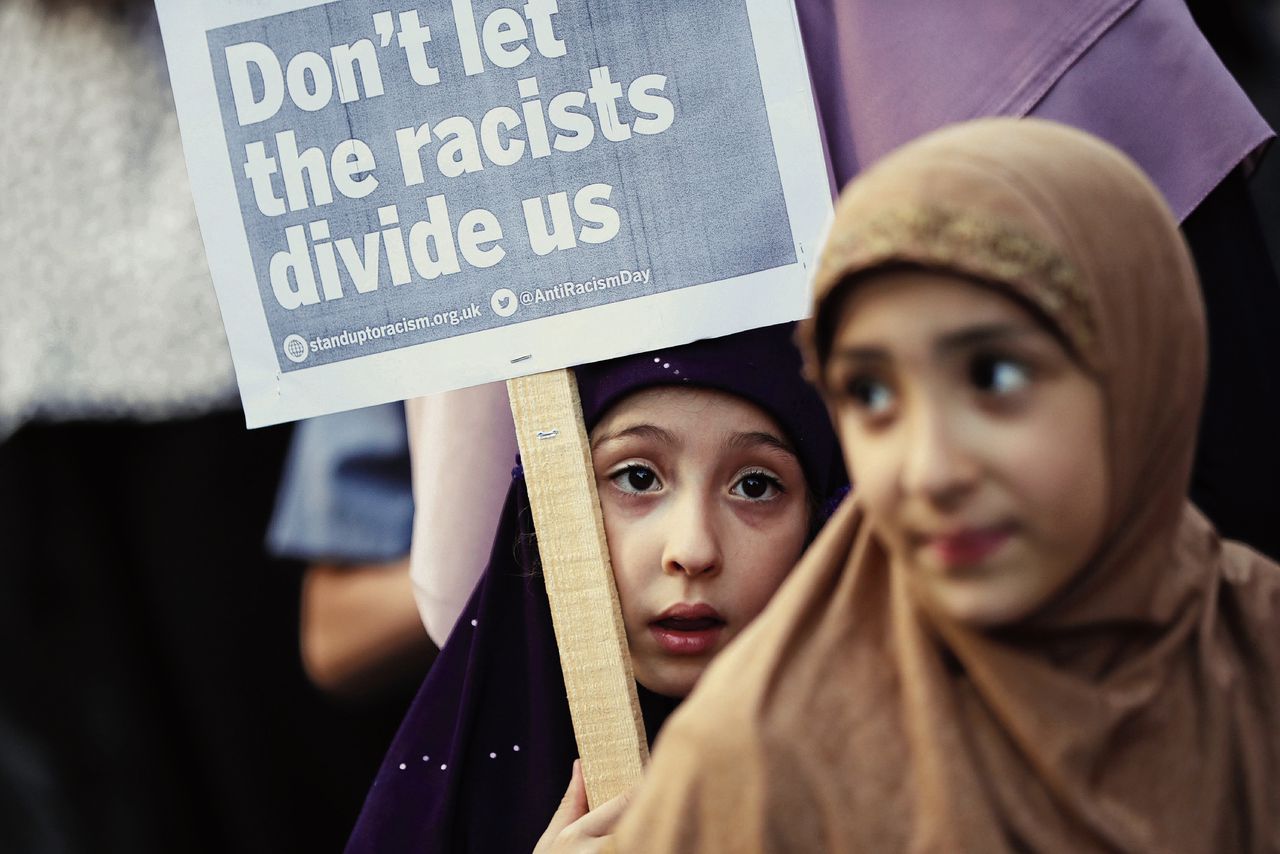 Een bijeenkomst na de aanslag in Noord-Londen, deze week. „Laat de racisten ons niet verdelen”, staat op het bord.