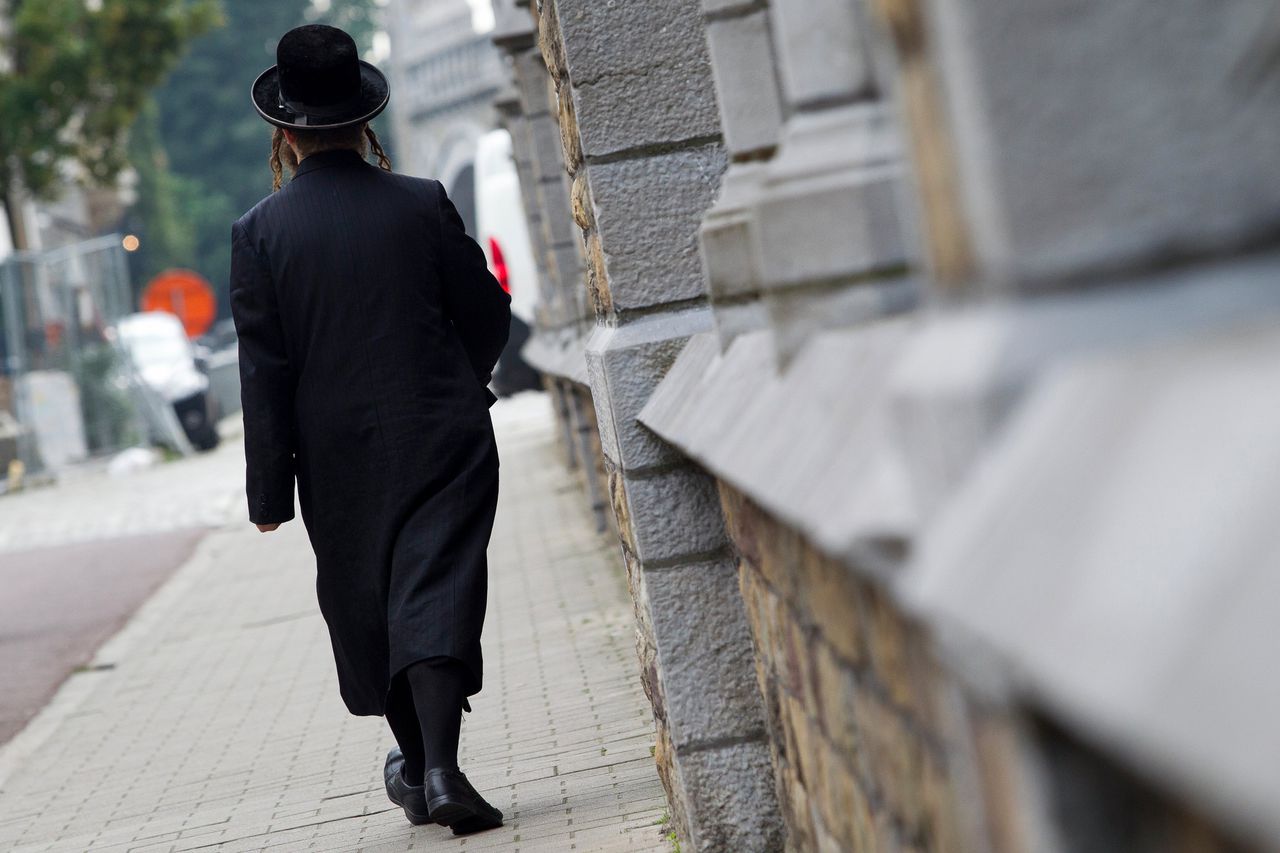 Een Joodse man loopt door de straten van Antwerpen.