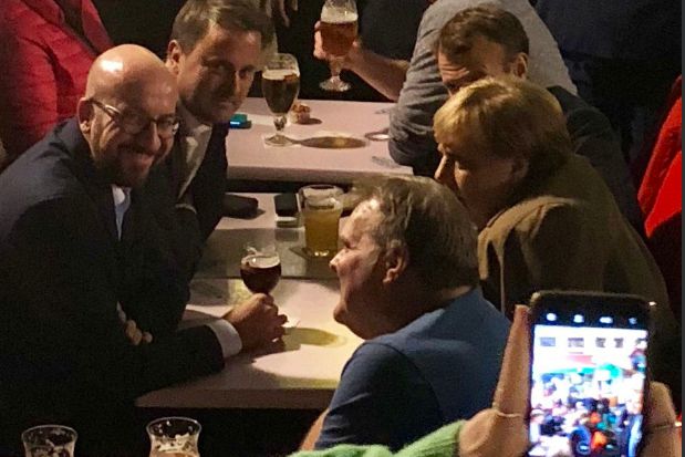 Na de top, in het café. Uiterst links de Belgische premier Michel, tegenover Merkel. Achter de bondskanselier president Macron.