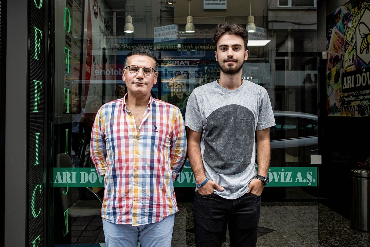 Ercan Gökdemir voor zijn wisselkantoor met zoon Hassan (17). „Ik heb flinke verliezen geleden.”