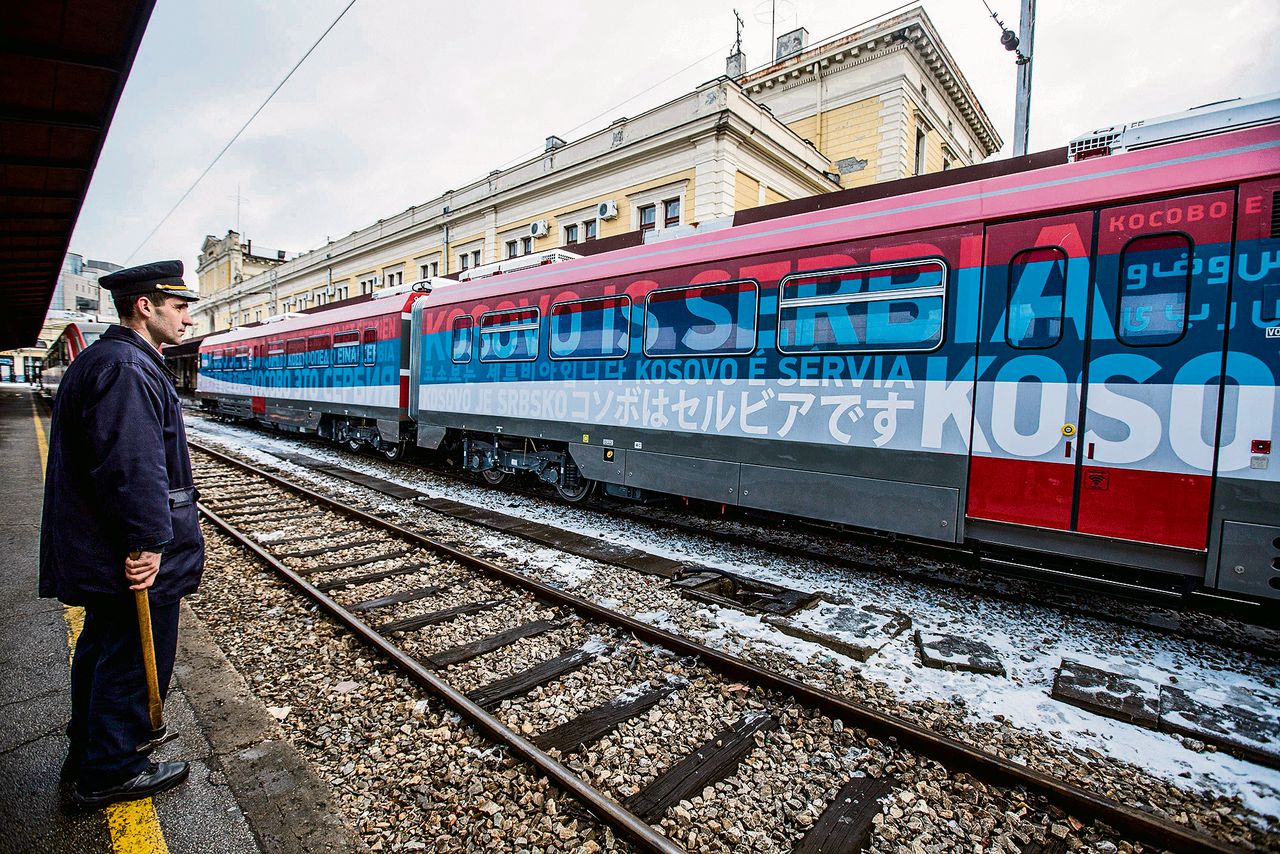 De omstreden trein met het opschrift ‘Kosovo is Servië’ op het station van Belgrado op 14 januari (boven). Een muurschildering van Poetin en Trump en dezelfde leuze als op de trein, woensdag in Belgrado.