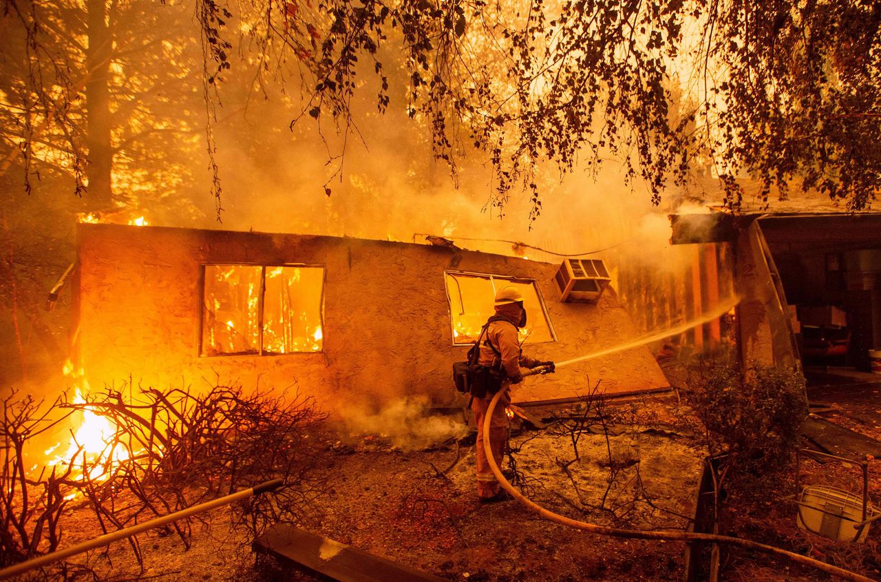 Brandweermannen proberen het vuur te doven bij een appartementencomplex in Paradise, ten noorden van Sacramento, Californië. De omvangrijke natuurbrand werd Camp Fire genoemd.