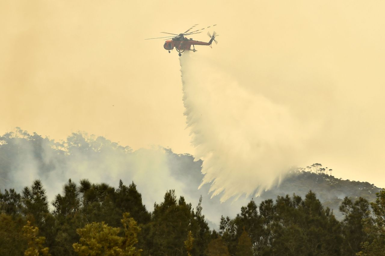 Een blushelikopter bestrijdt bosbranden in de deelstaat New South Wales.