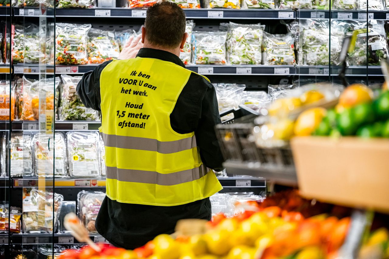 Een supermarktmedewerker in Eindhoven zorgt dat de schappen gevuld blijven.