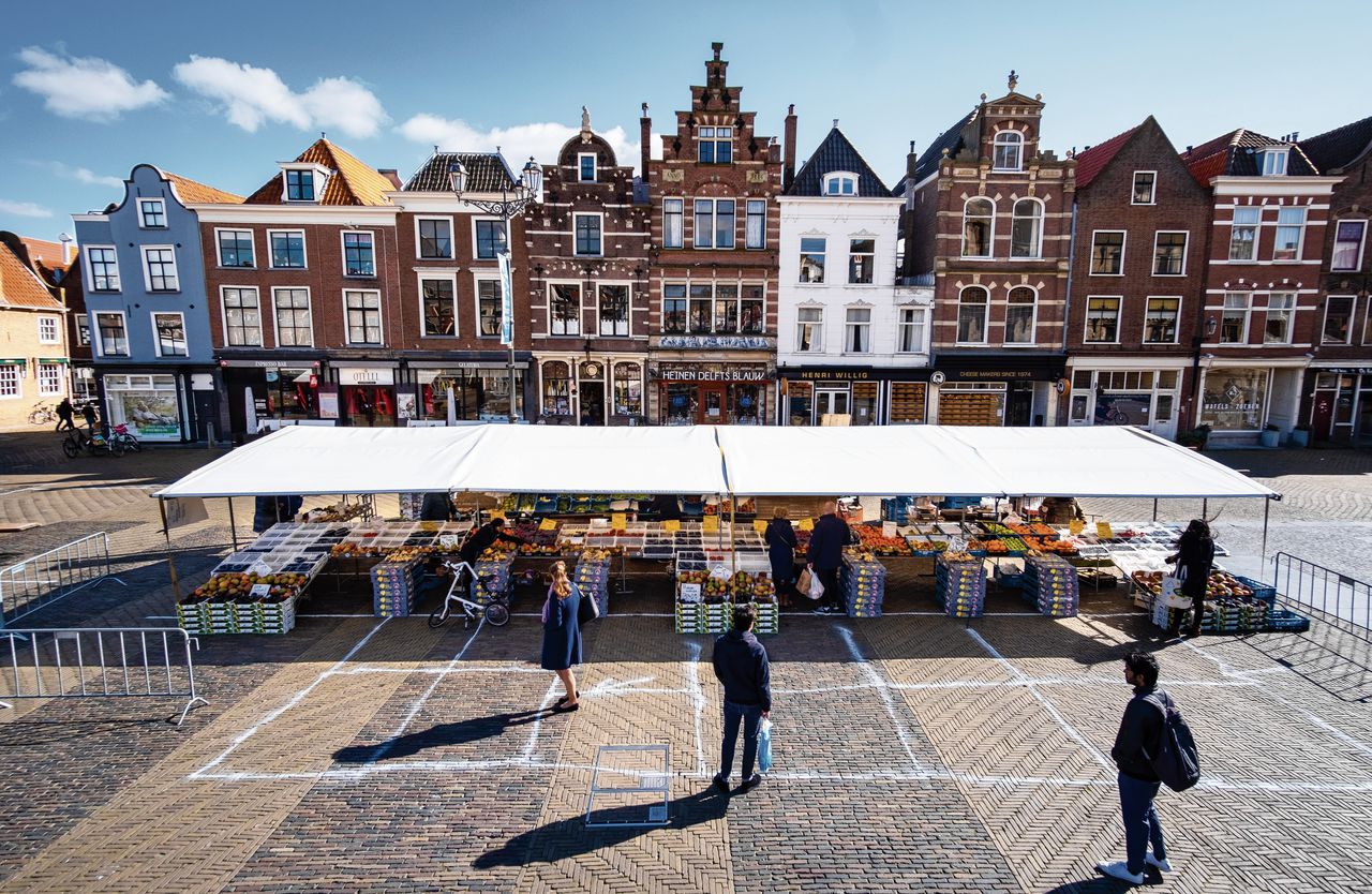 Op straat ontstaan nieuwe ‘verkeersregels’, zoals hier op de markt in Delft, waar vakken onderlinge afstand afdwingen.