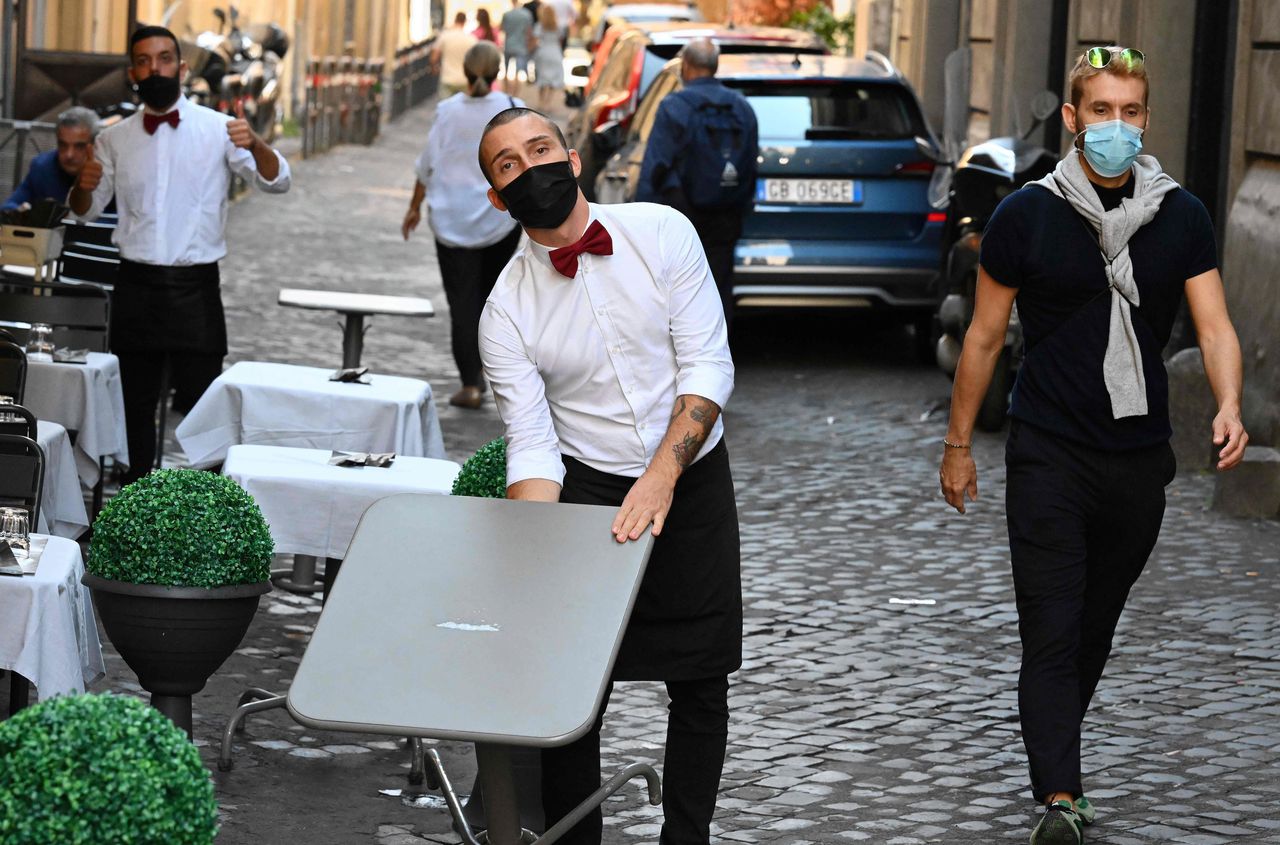 Obers van een restaurant in het centrum van Rome, waar veel mensen op straat mondmaskers dragen en waar de politie controleert of mensen niet te dicht op elkaar staan.