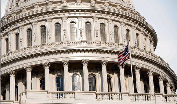 Een Amerikaanse vlag op Capitol Hill wappert in de wind terwijl het Huis van Afgevaardigden stemt over het aannemen van een wetsvoorstel om het Amerikaanse schuldenplafond te verhogen. Foto Reuters / Joshua Roberts