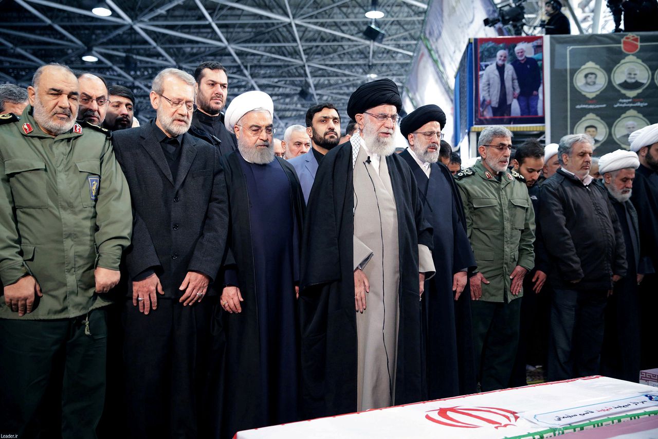 Ayatollah Ali Khamenei en president Hassan Rohani bidden naast de kist van de door de VS omgebrachte generaal Qassem Soleimani.