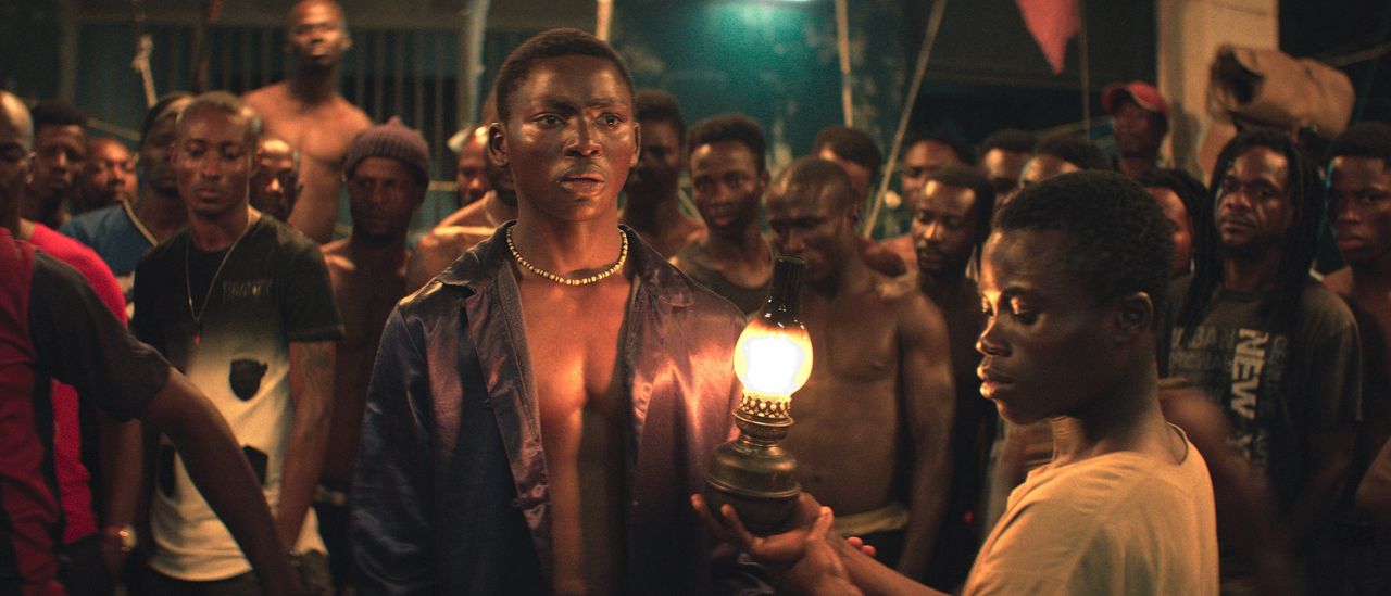 Een jongeman (Koné Bakary, midden) moet zich verhalen vertellen staande zien te houden in een levensgevaarlijke gevangenis in Ivoorkust, in ‘Night of the Kings’.