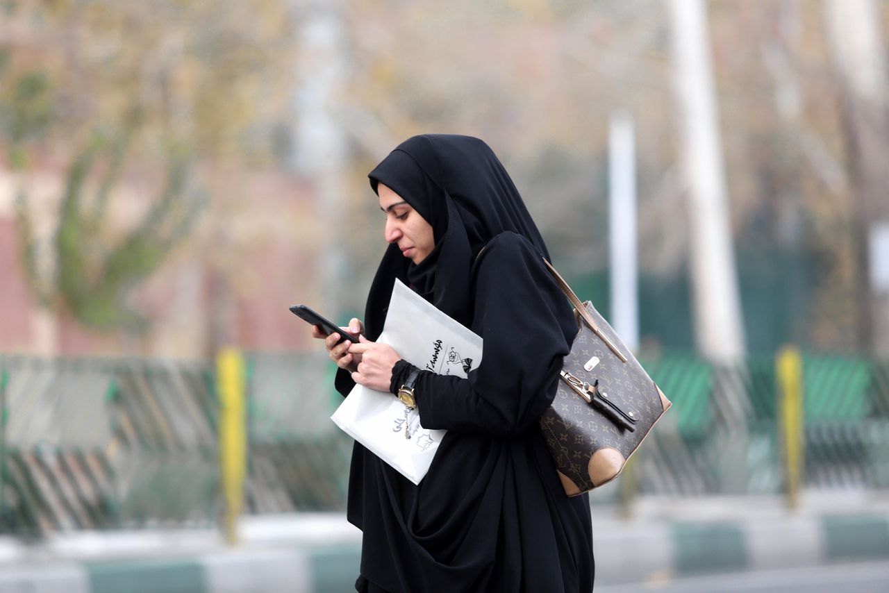 Een Iraanse vrouw in Teheran met haar smartphone. Een week lang was het internet nagenoeg volledig afgesloten.