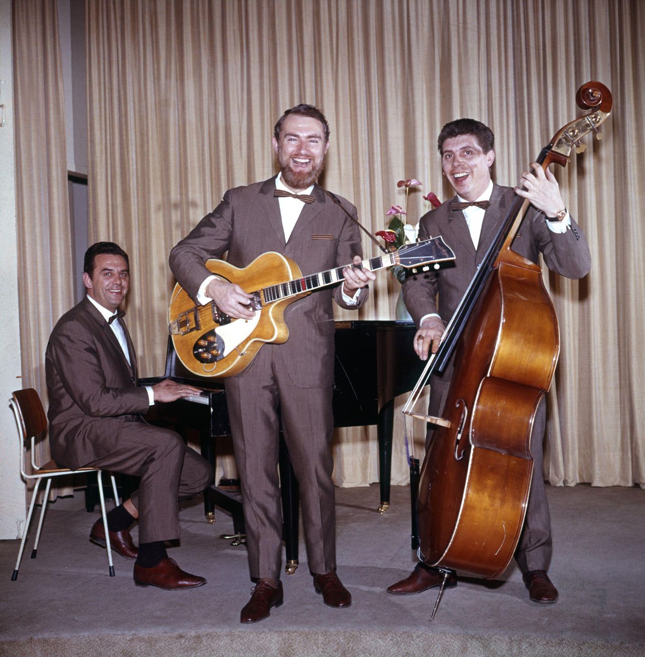 Cocktail Trio. Drie mannen in grijs kostuum en vlinderdas, treden op in een zaaltje met het nummer: " Het Vlooiencircus ". Plaats onbekend, 1965.