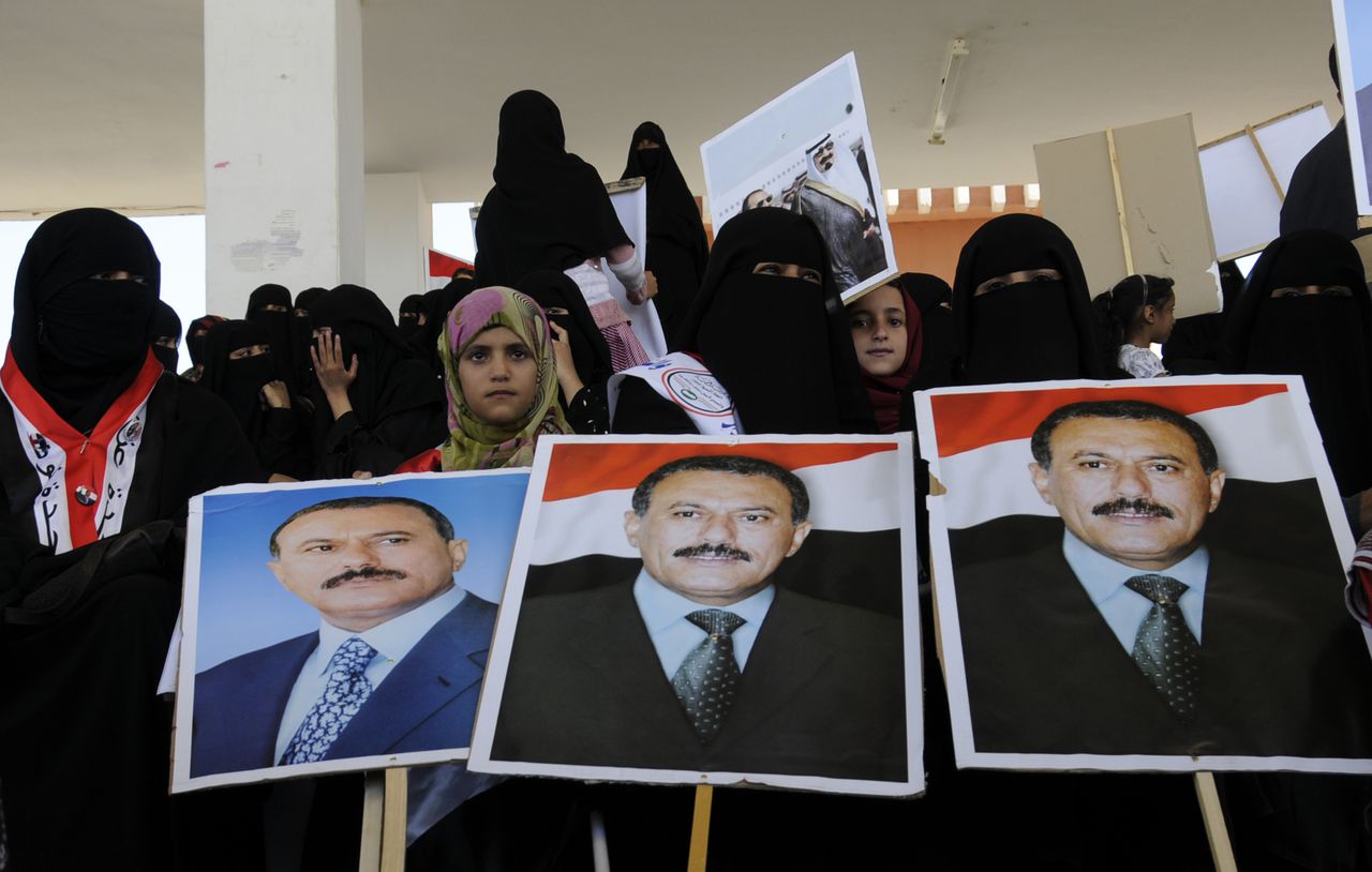 Aanhangers van president Saleh houden posters met zijn afbeelding vast in de hoofdstad Sana’a. De foto is gisteren genomen. Tegenstanders van Saleh gaan al maandenlang de straat op om zijn aftreden te eisen. De president heeft al meerdere keren bereidheid tot opstappen uitgesproken, maar de daad nog niet bij het woord gevoegd. Foto AP / Mohammed Hamoud