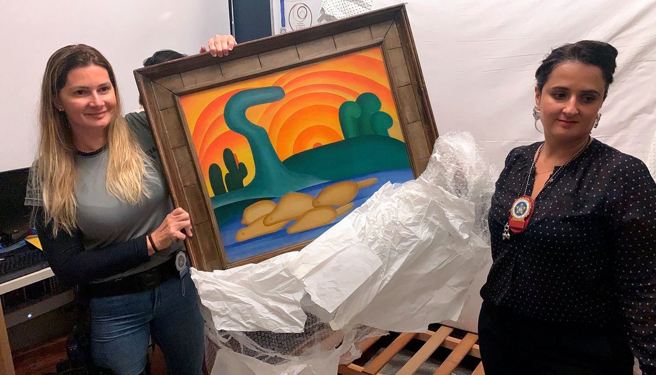 Rechercheurs tonen het gestolen schilderij ‘Sol Poente’ van de Braziliaanse kunstenaar Tarsila do Amaral, dat woensdag tijdens een politie-inval in Rio de Janeiro werd teruggevonden.