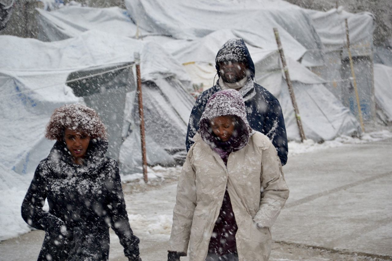 Vluchtelingen lopen in de sneeuw in een kamp op het Griekse eiland Lesbos.