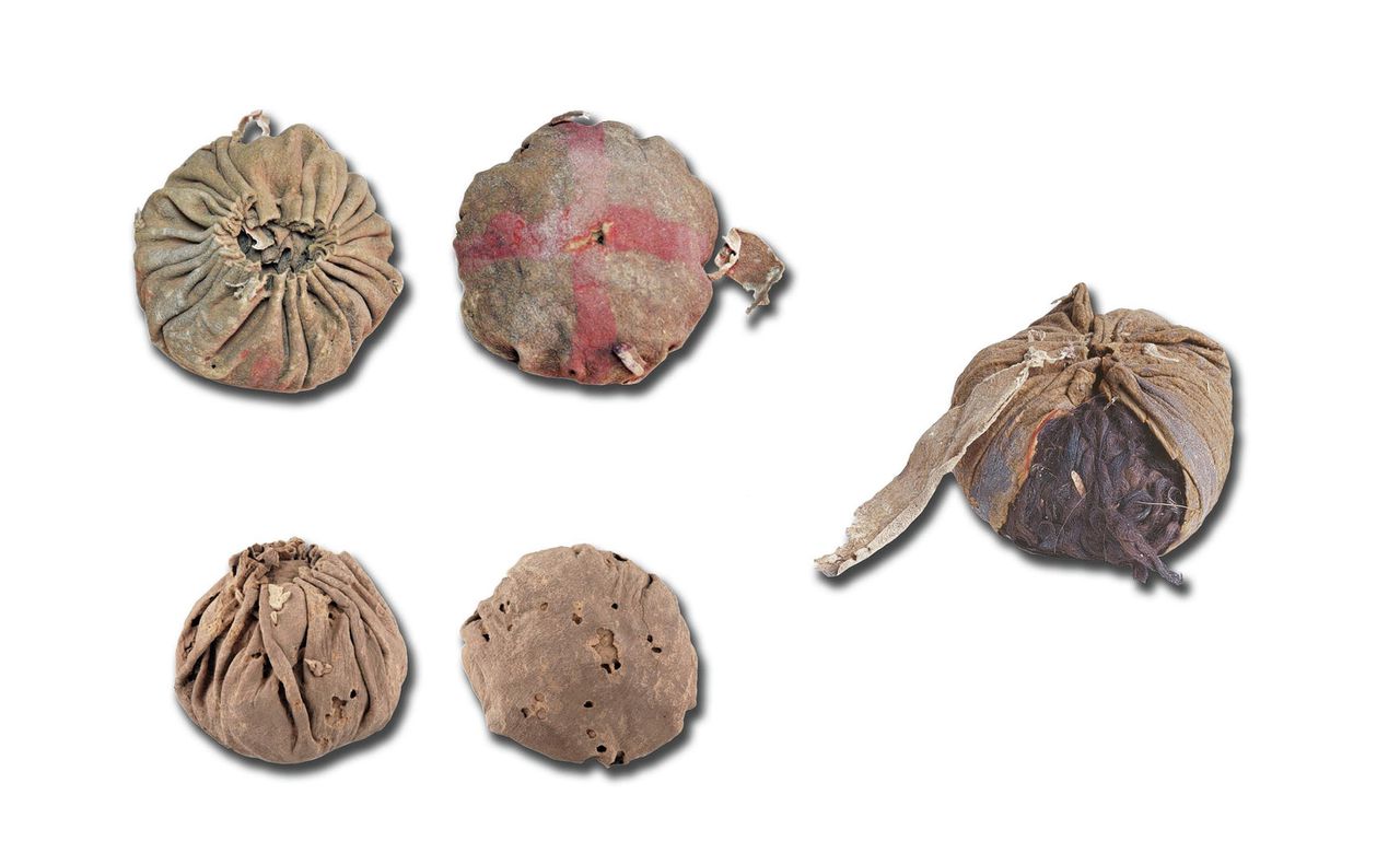 Drie leren ballen aangetroffen in een Chinees graf. Twee zijn er van boven en onder afgebeeld, de derde is opengewerkt.