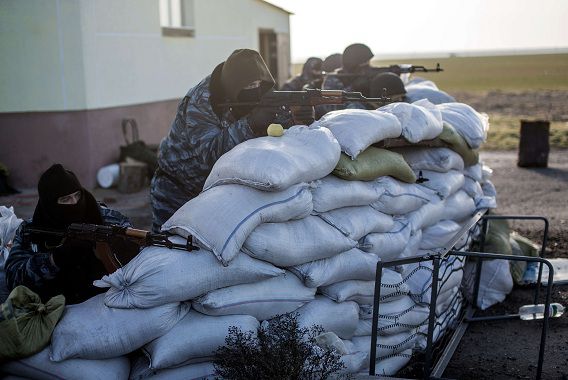 Gewapende Russische militairen bewaken de controlepost om de toegang op de Krim te blokkeren.