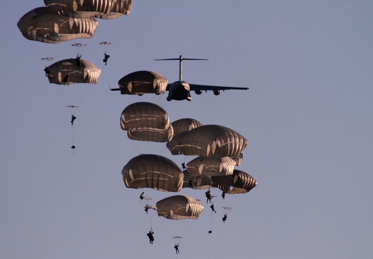 Amerikaanse soldaten springen uit een militair vliegtuig tijdens een oefening in Letland op 9 juni 2018.