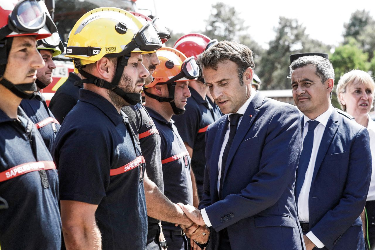De Franse president Emmanuel Macron (midden) en minister van Binnenlandse Zaken Gerald Darmanin (achter Macron) ontmoeten in juli brandweerlieden in La Teste-de-Buch, tijdens grote bosbranden in het zuidwesten van Frankrijk.