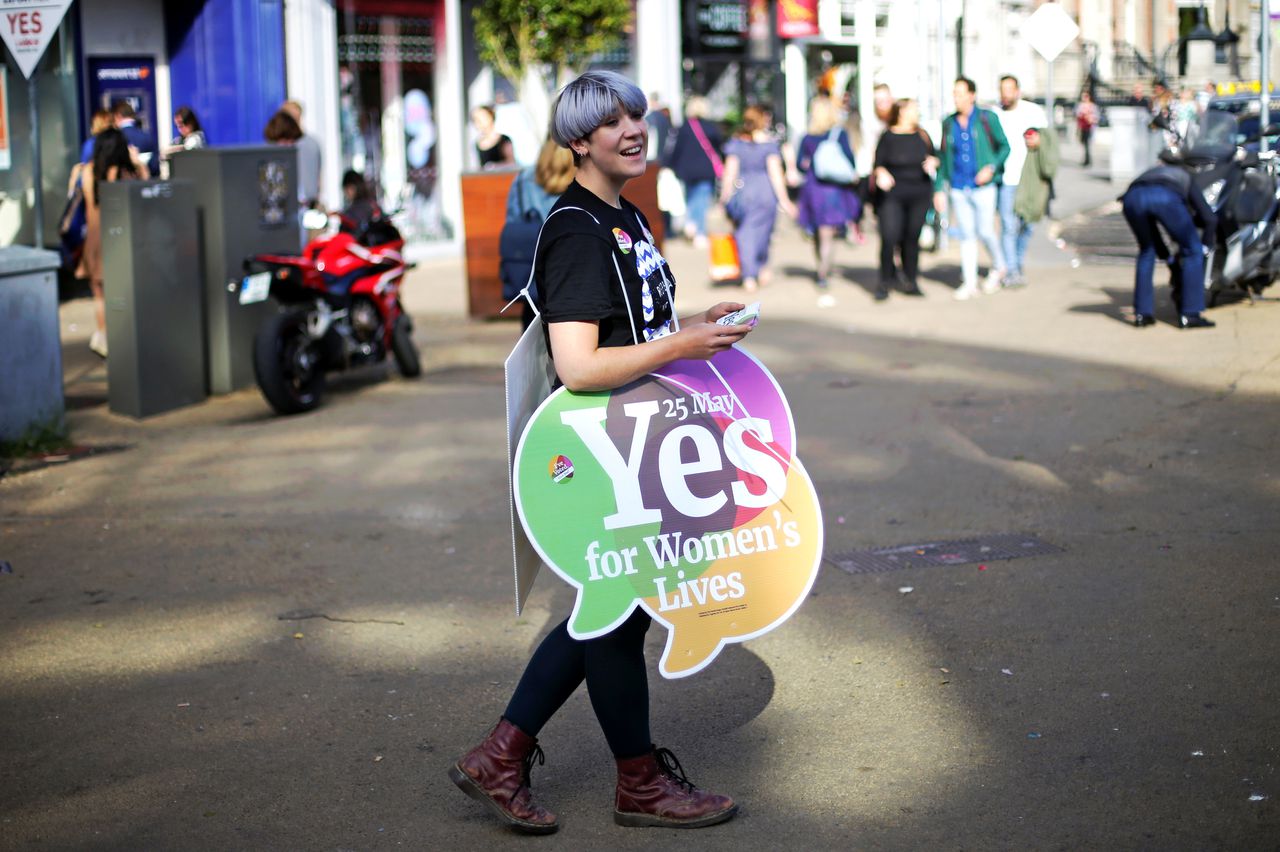 Een vrouw een campagnebord voor de 'ja'-zijde bij het Ierse referendum over abortus, vrijdag in de Ierse hoofstad Dublin.