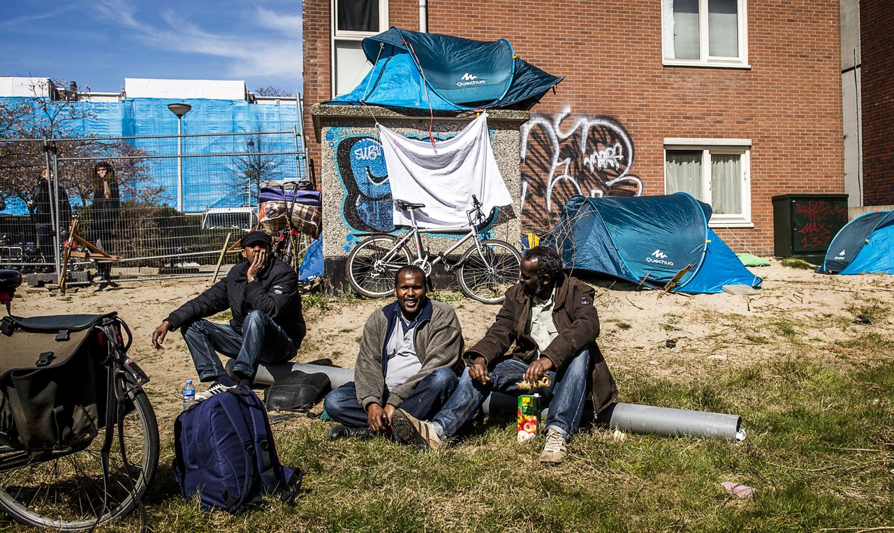 Asielzoekers afkomstig uit de ontruimde Vluchtgarage bij hun tentenkamp op een bouwterrein in de Pijp.