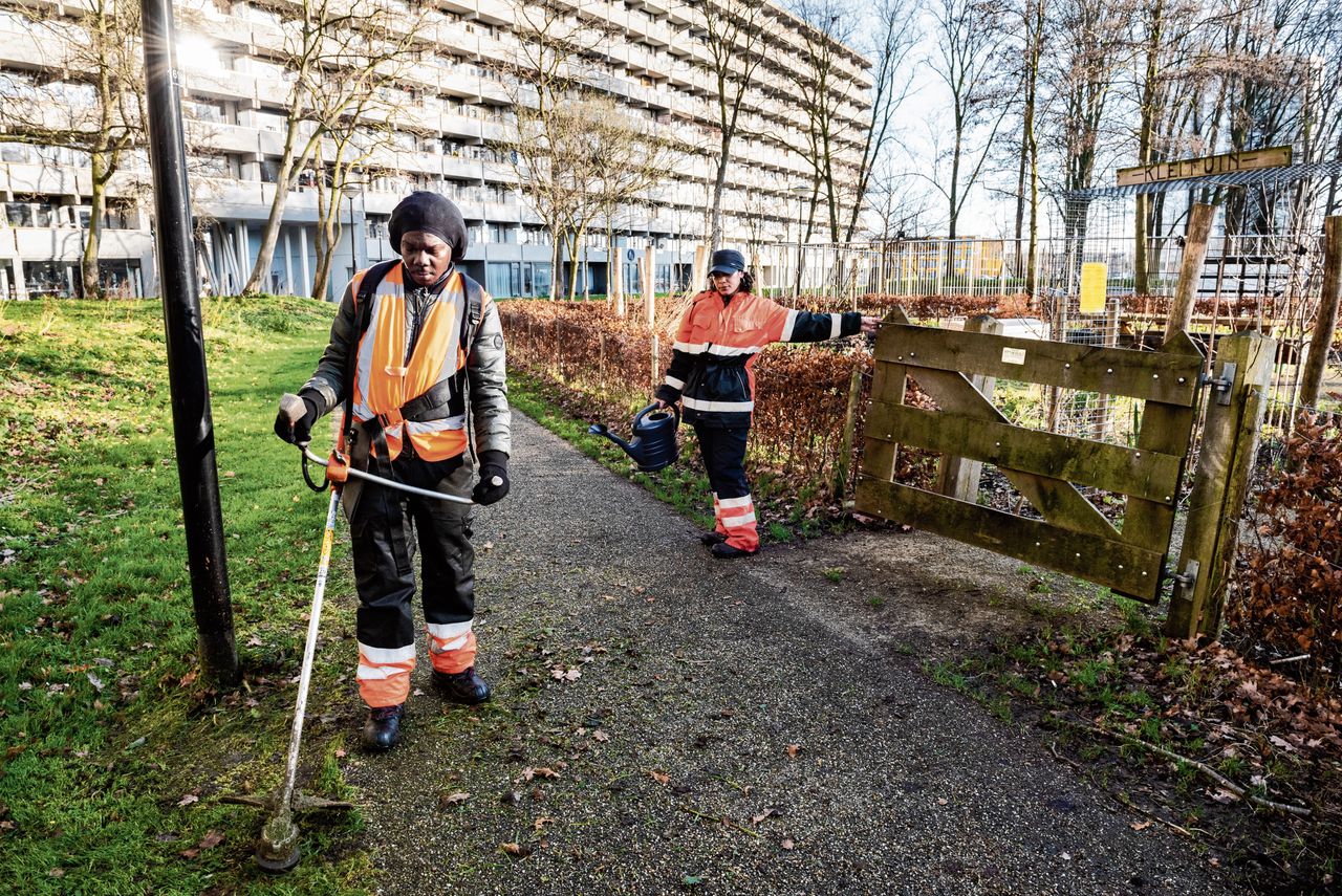 Marvin Wiebers en Charise Weij van de Werkbrigade doen groenonderhoud in een park in Amsterdam-Zuidoost.