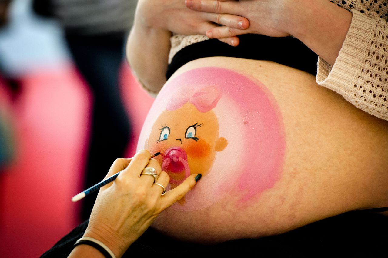 Een aanstaande moeder laat haar zwangere buik beschilderen tijdens de Negenmaandenbeurs twee jaar geleden.