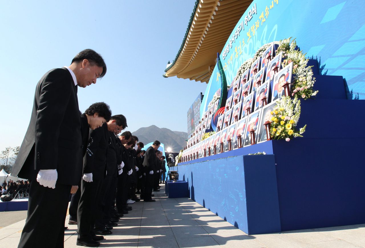 Familieleden van de omgekomen mariniers buigen hun hoofden bij een herdenking van het zinken van de ROKS Cheonan