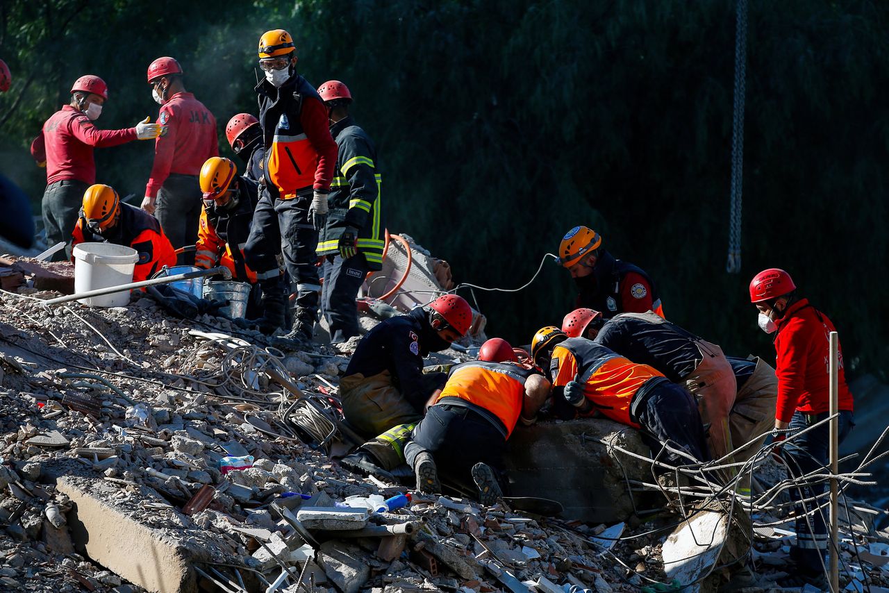 Reddingsdiensten zoeken naar overlevenden in het puin in Izmir na de aardbeving.