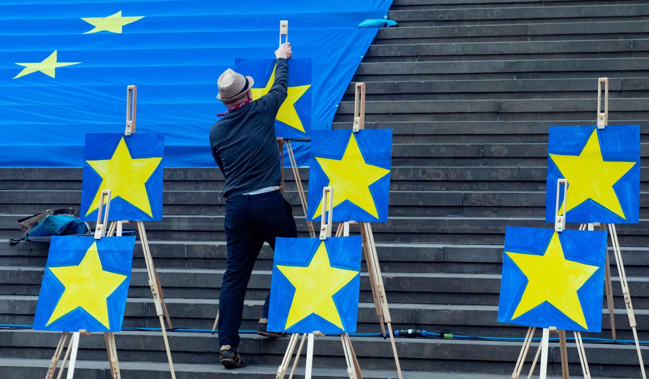Een man plaatst Europese ‘sterren’ tijdens een pro-Europese demonstratie in Berlijn, afgelopen zondag.