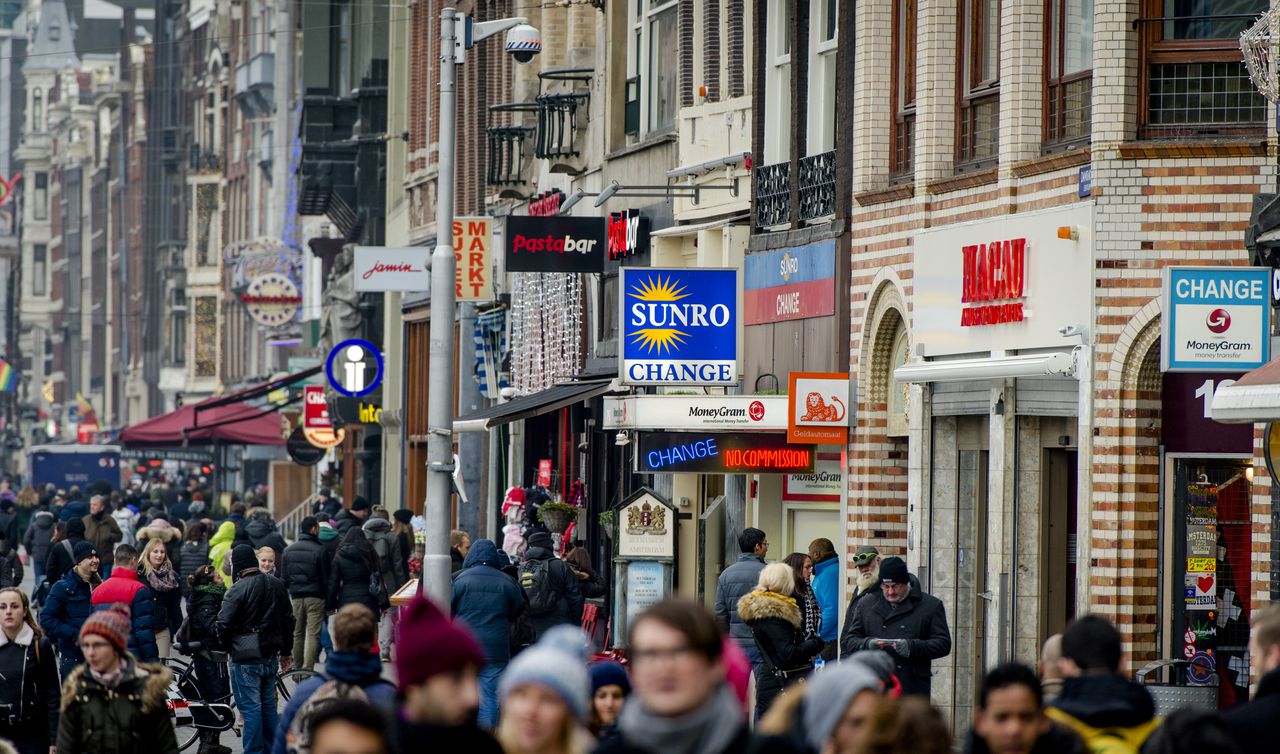 Voetgangers op het Damrak in Amsterdam. Het vertrouwen van consumenten bereikt deze maand het hoogste niveau in bijna acht jaar tijd.