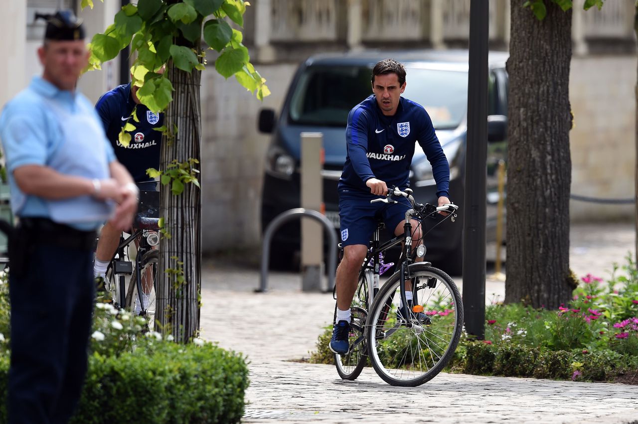 Gary Neville, assistent-bondscoach van het Engelse voetbalelftal, verlaat het luxueuze Auberge du Jeu Paume per fiets.