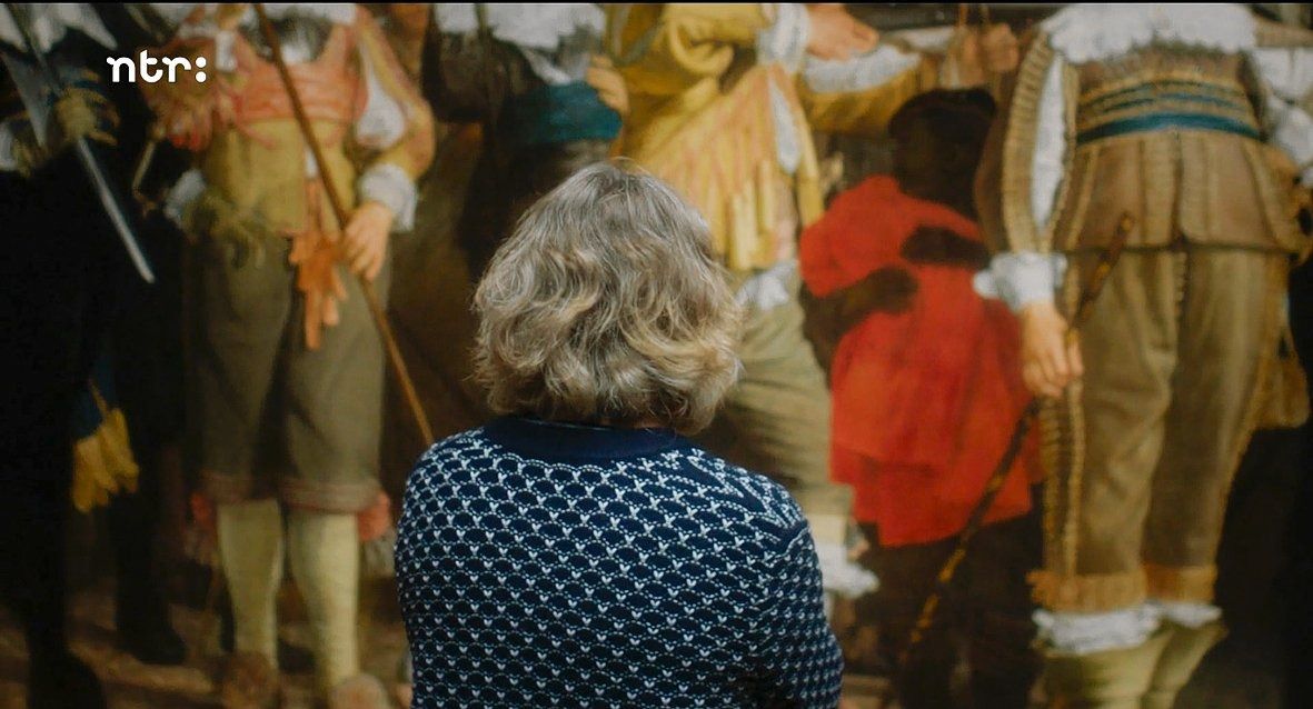 Conservator Eveline Sint-Nicolaas kijkt naar de zwarte jongen op een schuttersstuk in Nieuw licht. Het Rijksmuseum en de slavernij (NTR).