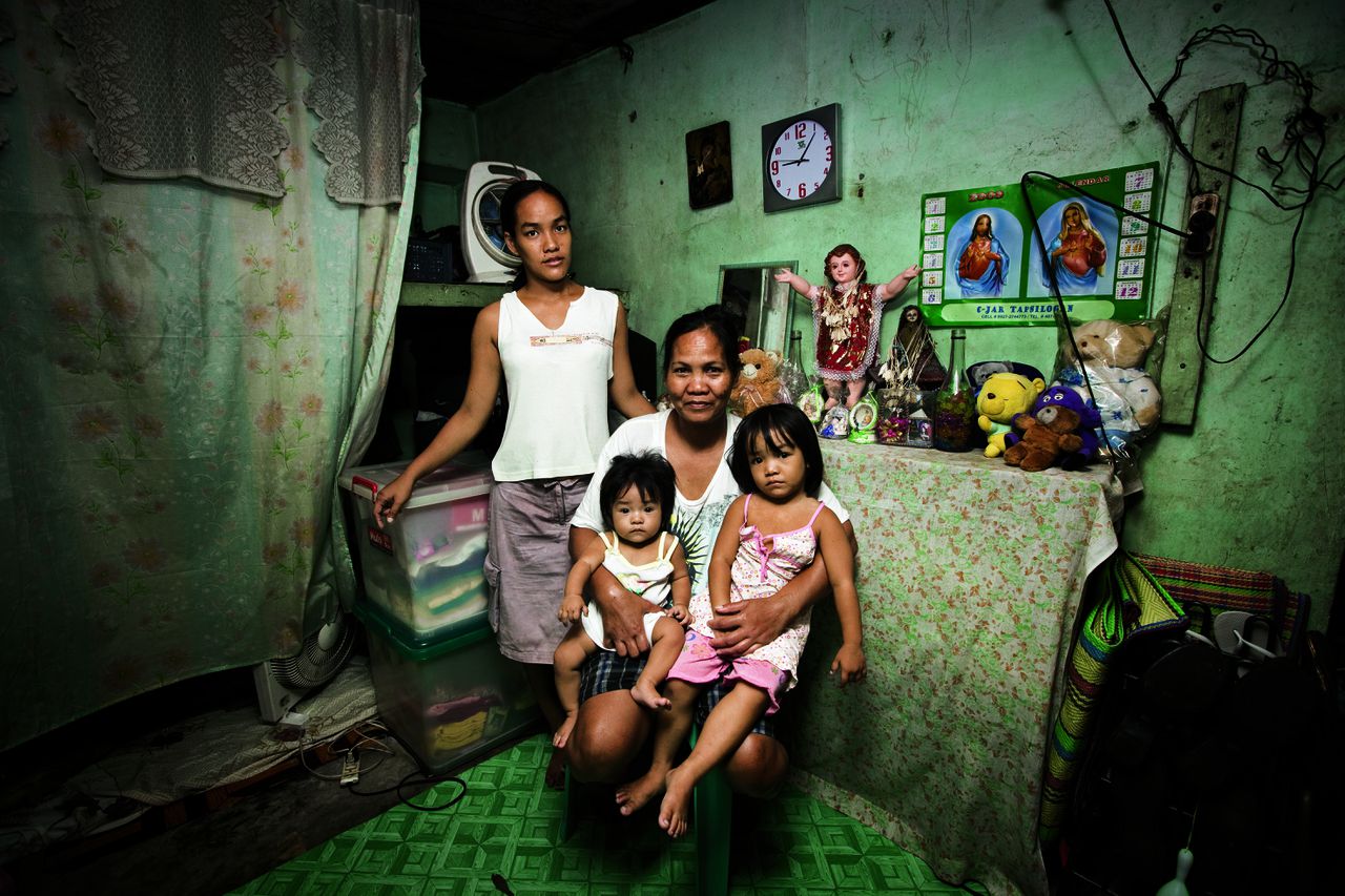 Jesusan Benjamin met haar kleinkinderen in de wijk Bagung Barrio in Manila. Ze heeft als huishoudster in Koeweit gewerkt. Het eerste jaar wisselde zezeven keer van werkgever. Veel geld heeft ze er niet aan overgehouden. Haar salaris was laag. Geen van haar vijf kinderen kon studeren.