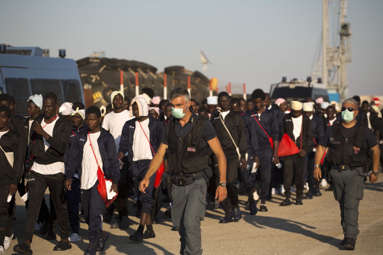 De Italiaanse politie escorteert migranten naar een asielzoekerscentrum op Sicilië.