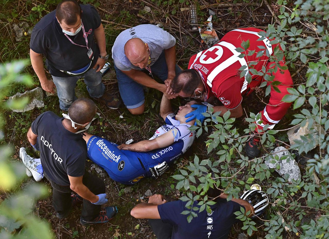 De Belgische renner Remco Evenepoel wordt verzorgd na zijn val van een viaduct.