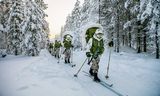 Rekruten van de grenswacht gebruiken langlaufski's tijdens de training in het bos. Ze brengen de nacht buiten door bij temperaturen die dalen tot dertig graden onder nul.