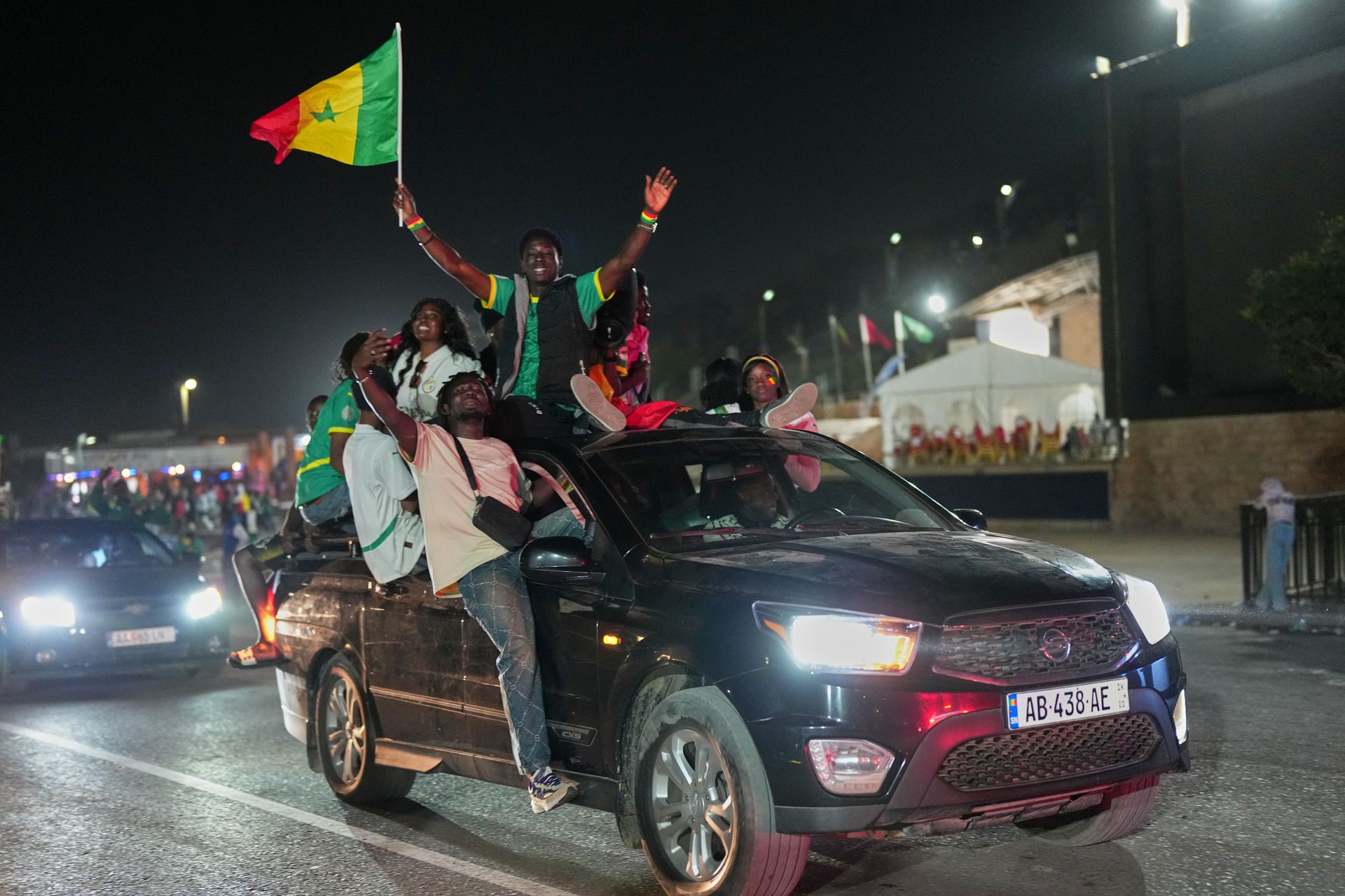 Los aficionados en el Dakar celebran la victoria de Senegal en un coche a toda velocidad.
