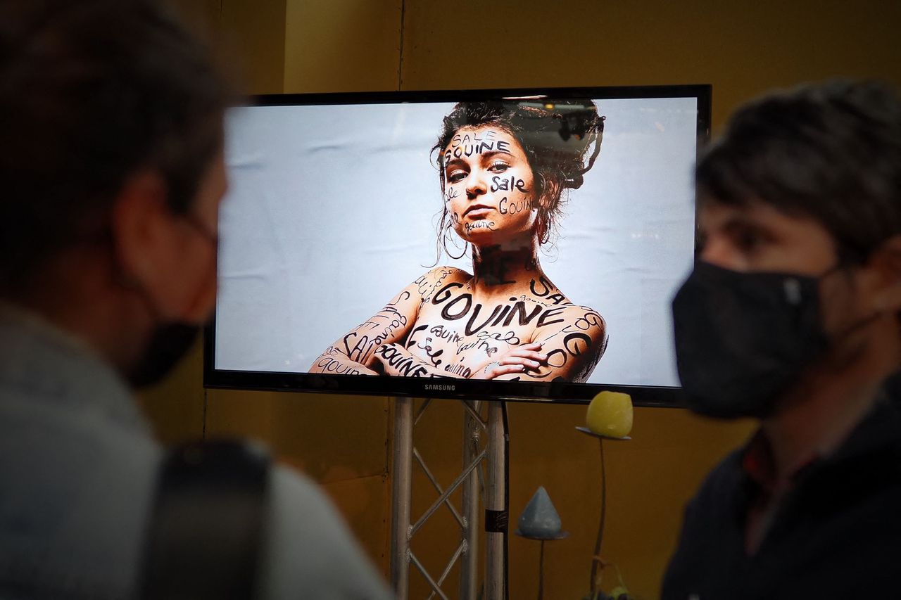 Bij een bewustwordingscampagne tegen gendergerelateerd geweld kijken mensen in Bourges, Frankrijk, naar een video.