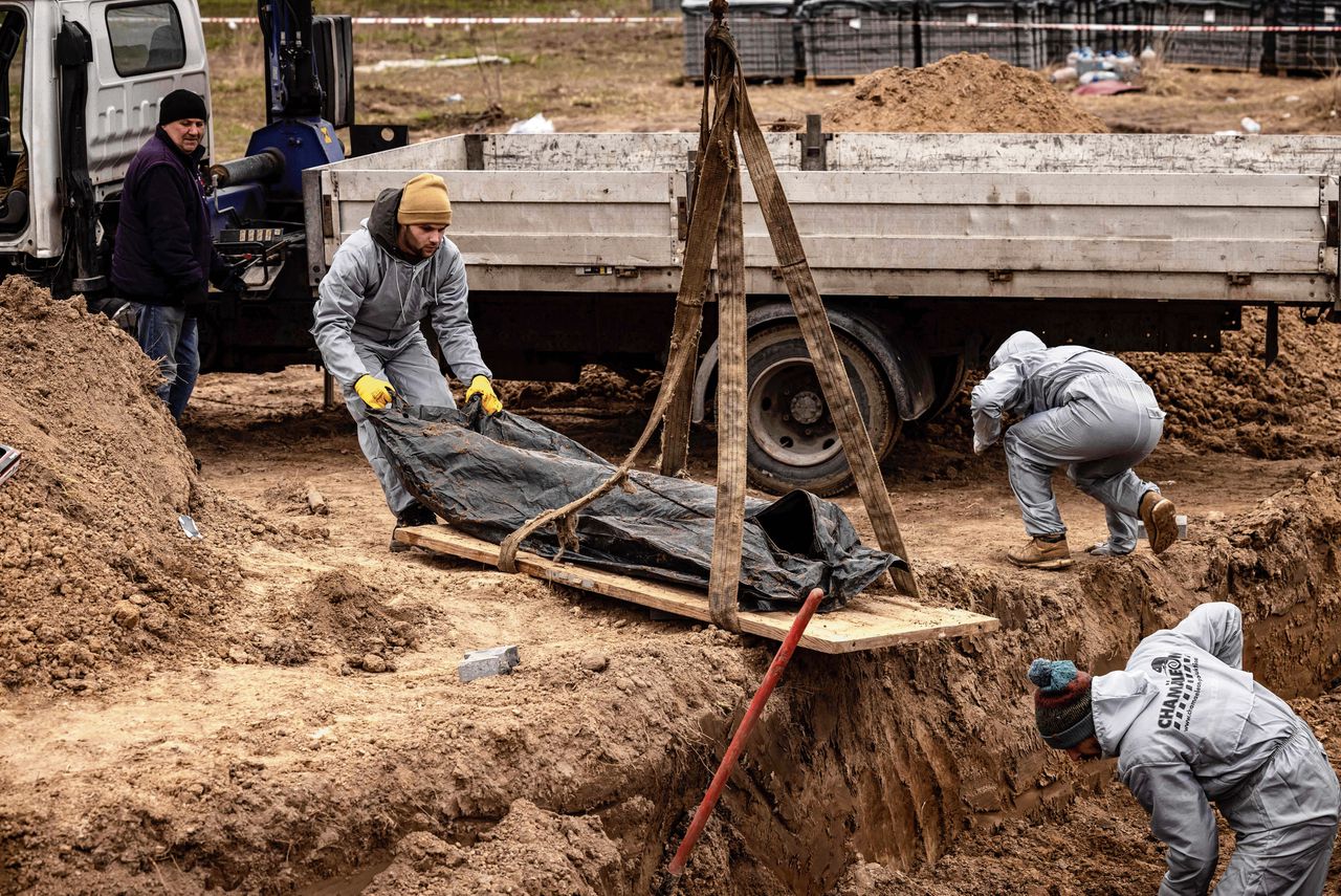 Lichamen van Oekraïense burgers worden opgegraven op het terrein van de kerk van Sint-Andreas in Boetsja, een voorstad van Kiev.