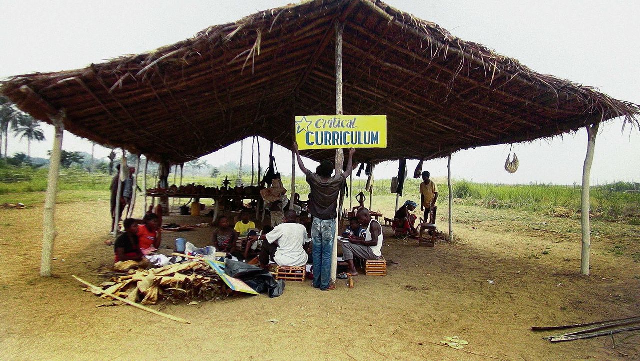 Boven: De lancering van het ‘critical curriculum’ van het Instituut voor Menselijke Activiteiten op de nieuwe, geheime locatie in Congo, 2014