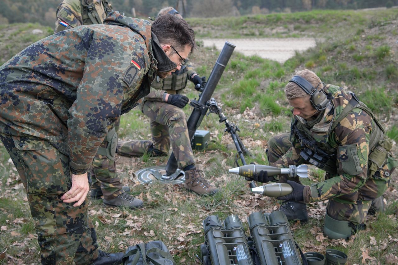 Een Duitse militaire veiligheidsspecialist controleert Nederlandse 81 mm-mortieren tijdens een gezamenlijke oefening in Duitsland