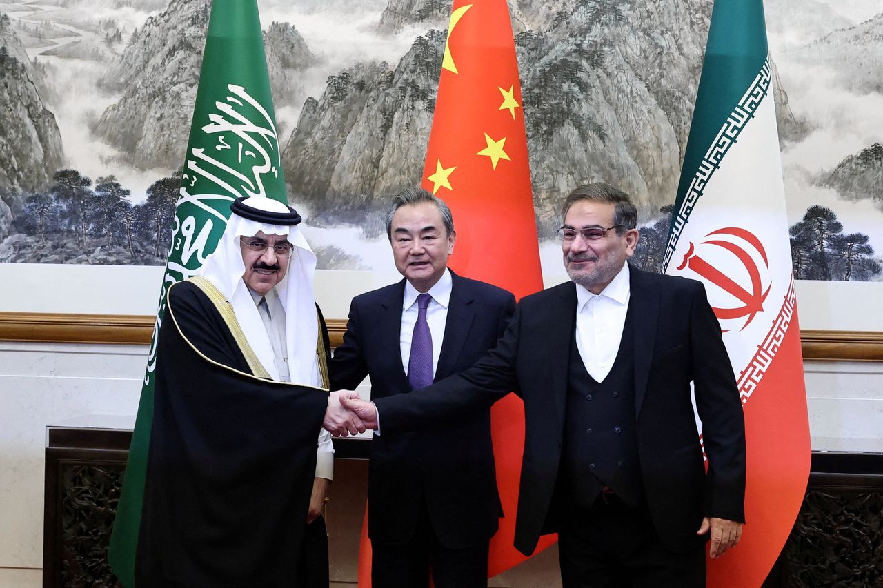 De Saoedische en Iraanse onderhandelaars Musaed bin Mohammed Al-Aiban (links) en Ali Shamkhani (rechts) vrijdag in Beijing met de Chinese topdiplomaat Wang Yi.