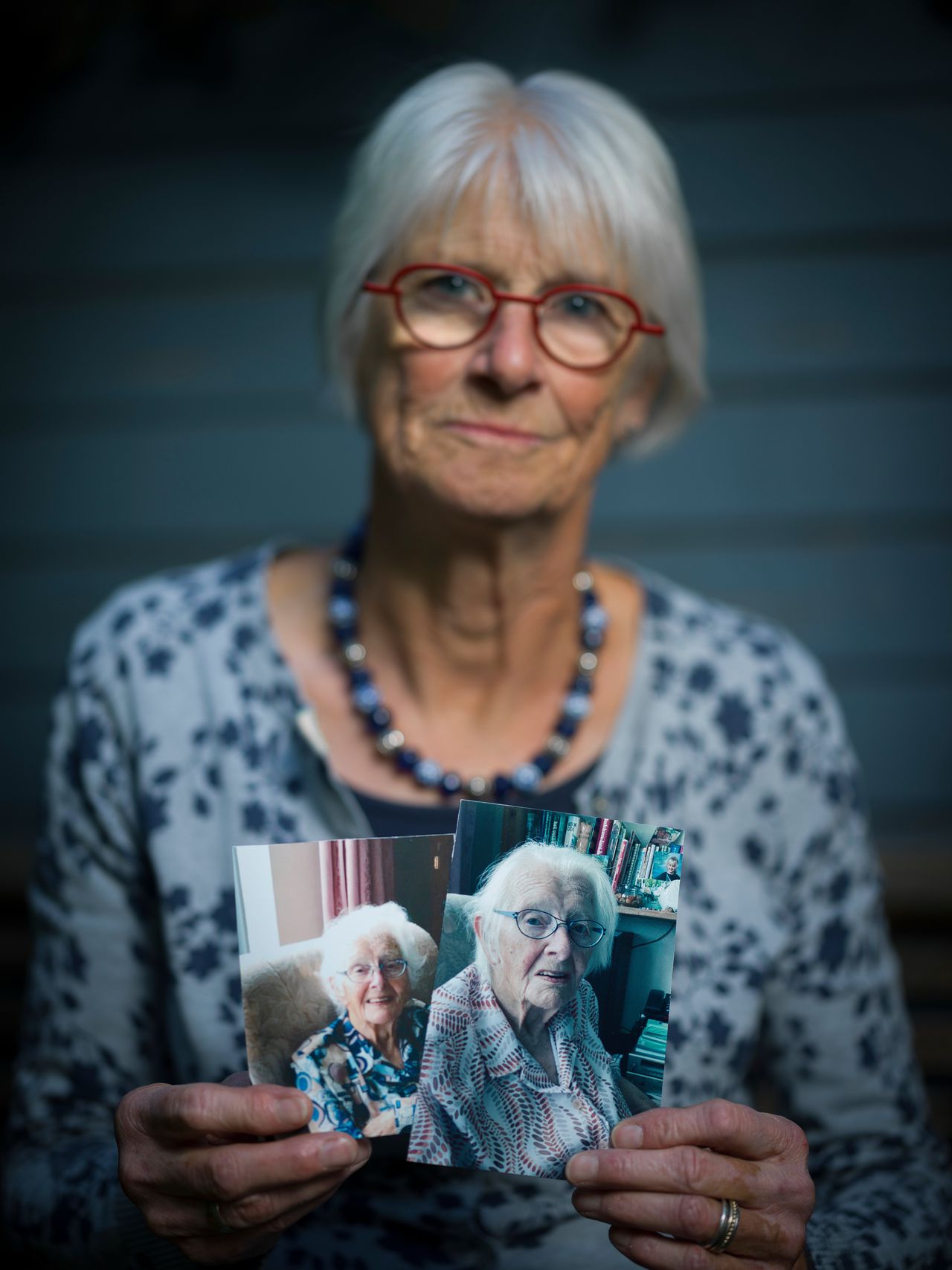 Magda Klyn houdt twee foto's van haar moeder vast - links een paar weken voor de lockdown, rechts een recente foto na een paar weken lockdown.