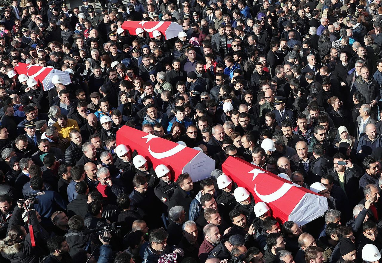 De doodskisten van omgekomen agenten worden gedragen tijdens hun begrafenis.