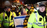 Politieagenten leiden een vrouw met een Israëlische vlag weg van het pro-Palestijnse protest.
