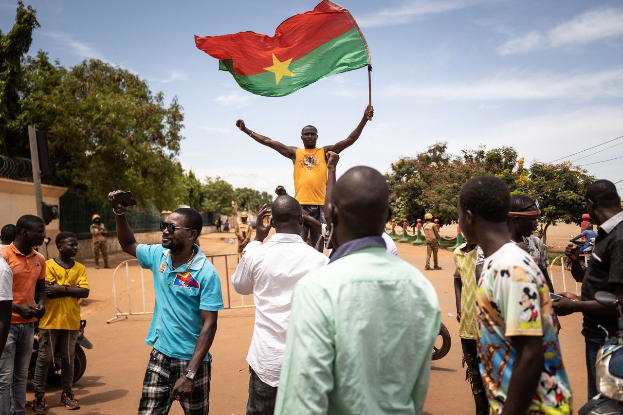 Een man zwaait vrijdag met een vlag van Burkina Faso tijdens een demonstratie in de hoofdstad Ouagadougou tegen de achtergrond van een machtsovername door militairen in het West-Afrikaanse land.