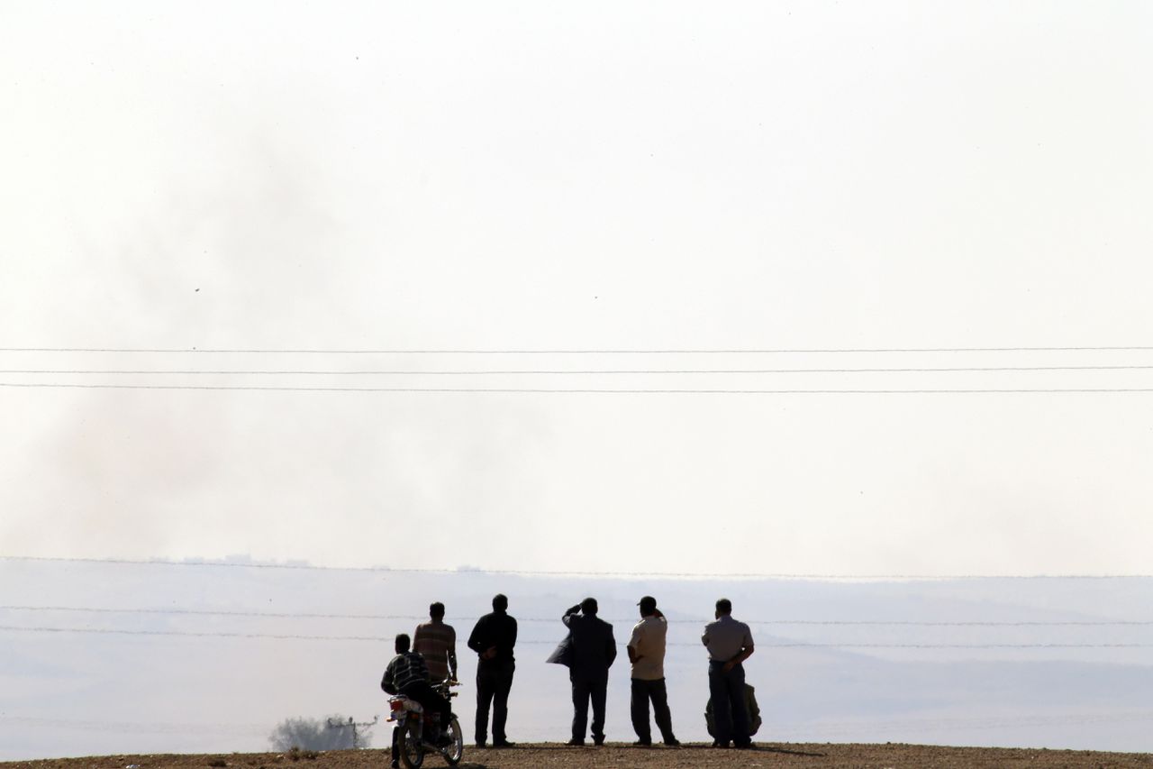 Turkse Koerden kijken naar gevechten van IS en Koerdische troepen in Kobani, Syrië.