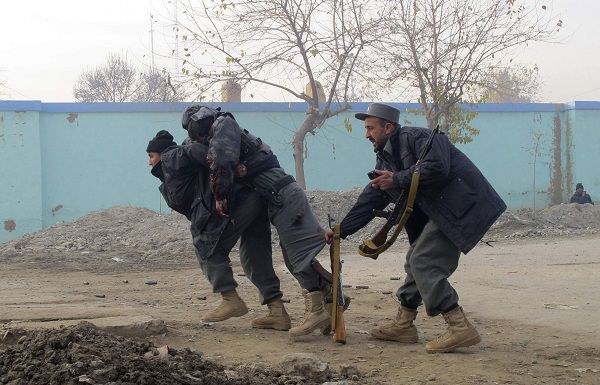 ATTENTION EDITORS - VISUAL COVERAGE OF SCENES OF DEATH AND INJURY A wounded Afghan policeman is carried away by his comrades during a gunbattle with suicide bombers in Kunduz province December 19, 2010. Three Afghan soldiers and two policemen were killed in an attack by at least three suicide bombers on an army recruitment centre in the northern city of Kunduz, the city's police chief said. The Defence Ministry said four bombers attacked the centre and that two had been killed and the remaining two were trapped inside. REUTERS/ Stringer (AFGHANISTAN - Tags: CIVIL UNREST) TEMPLATE OUT