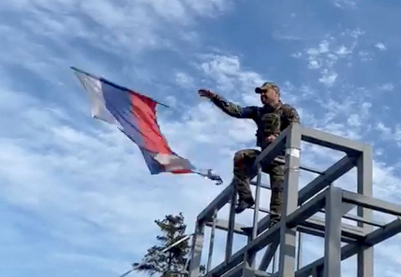 Een vermoedelijk Oekraïense militair in het het Oost-Oekraïense Lyman werpt een Russische vlag naar beneden, 1 oktober. Dit beeld is verkregen via derden en daarom lastig te verifiëren.